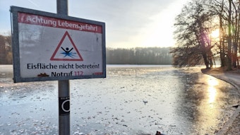 Ein Warnschild am Adenauer Weiher weist auf die Gefahr beim Betreten der Eisfläche hin.