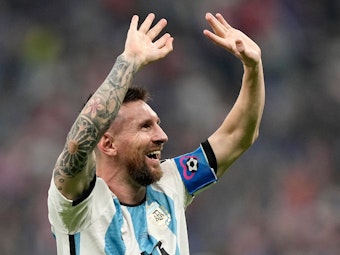 Lionel Messi freut sich und reißt die Arme nach oben.