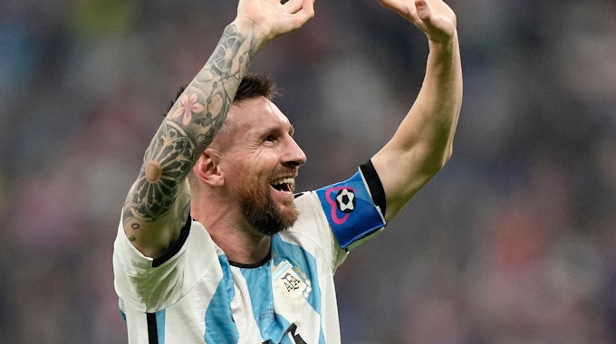 Lionel Messi freut sich und reißt die Arme nach oben.