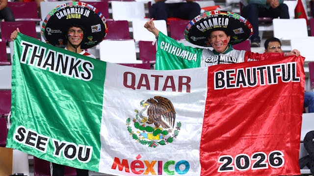 Fans aus Mexiko stehen vor dem Spiel mit einer Flagge auf der Tribüne.