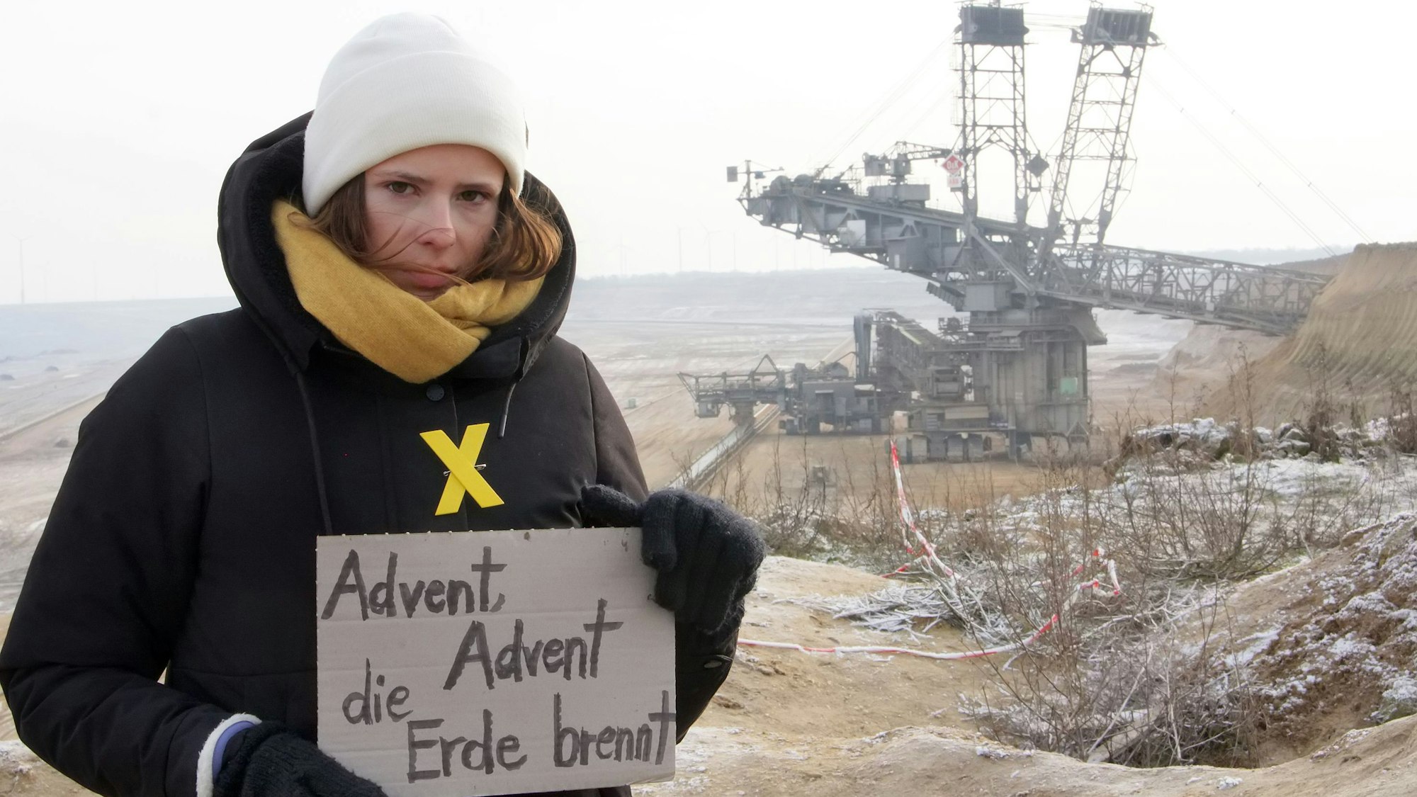 Luisa Neubauer hält in Erkelenz-Lützerath ein Protestschild hoch.