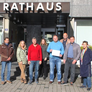 Bürgerinnen und Bürger von Blankenheim stehen mit dem Anmeldebogen des Bürgerbescheides vor dem Rathaus.