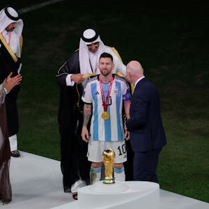 Katars Emir Sheikh Tamim bin Hamad al-Thani stülpt Lionel Messi das arabische Gewand über.&nbsp;