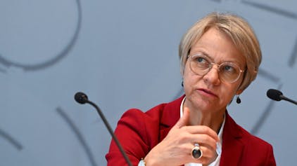 Dorothee Feller (CDU), Schulministerin von Nordrhein-Westfalen, sitzt an einem Mikrofon und spricht zu Publikum.