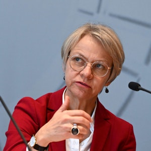 Dorothee Feller (CDU), Schulministerin von Nordrhein-Westfalen, sitzt an einem Mikrofon und spricht zu Publikum.