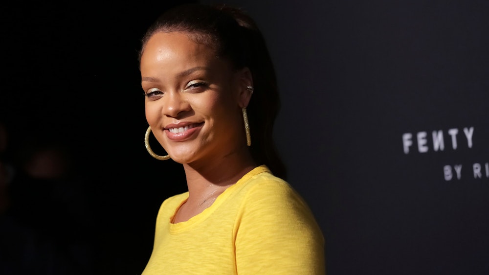 Popstar Rihanna lacht in die Kamera.