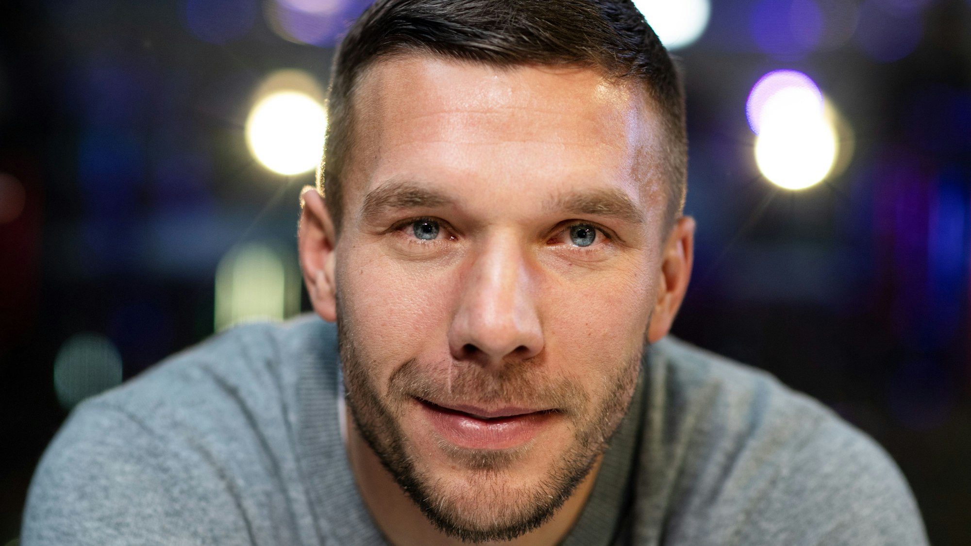 Lukas Podolski lächelt in die Kamera.
