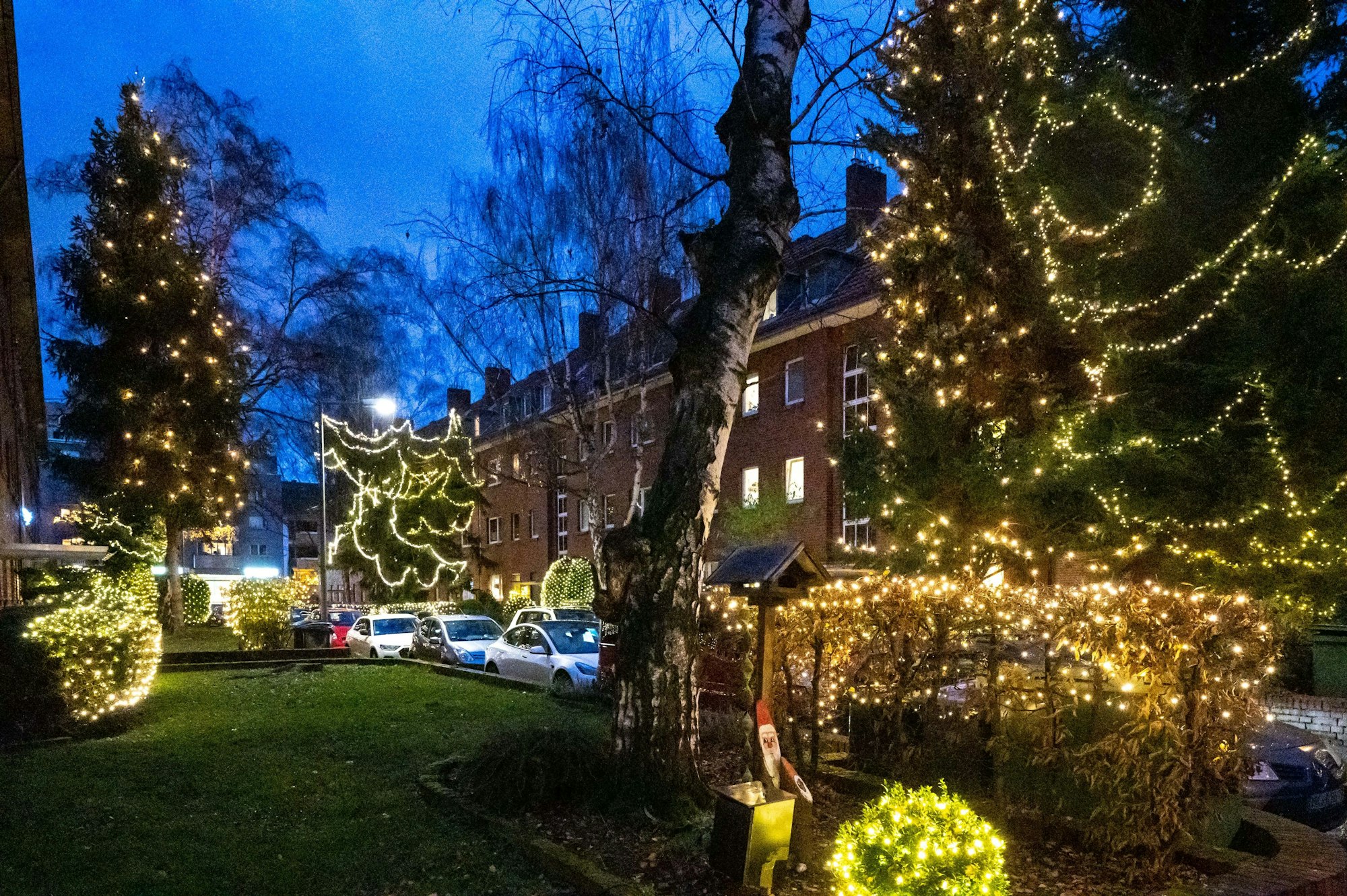 Auf diesem im Jahr 2021 aufgenommenen Foto ist die Hummelsbergstraße weihnachtlich erleuchtet. In Bäumen, Hecken und Sträuchern hängen zahlreiche Lichterketten.