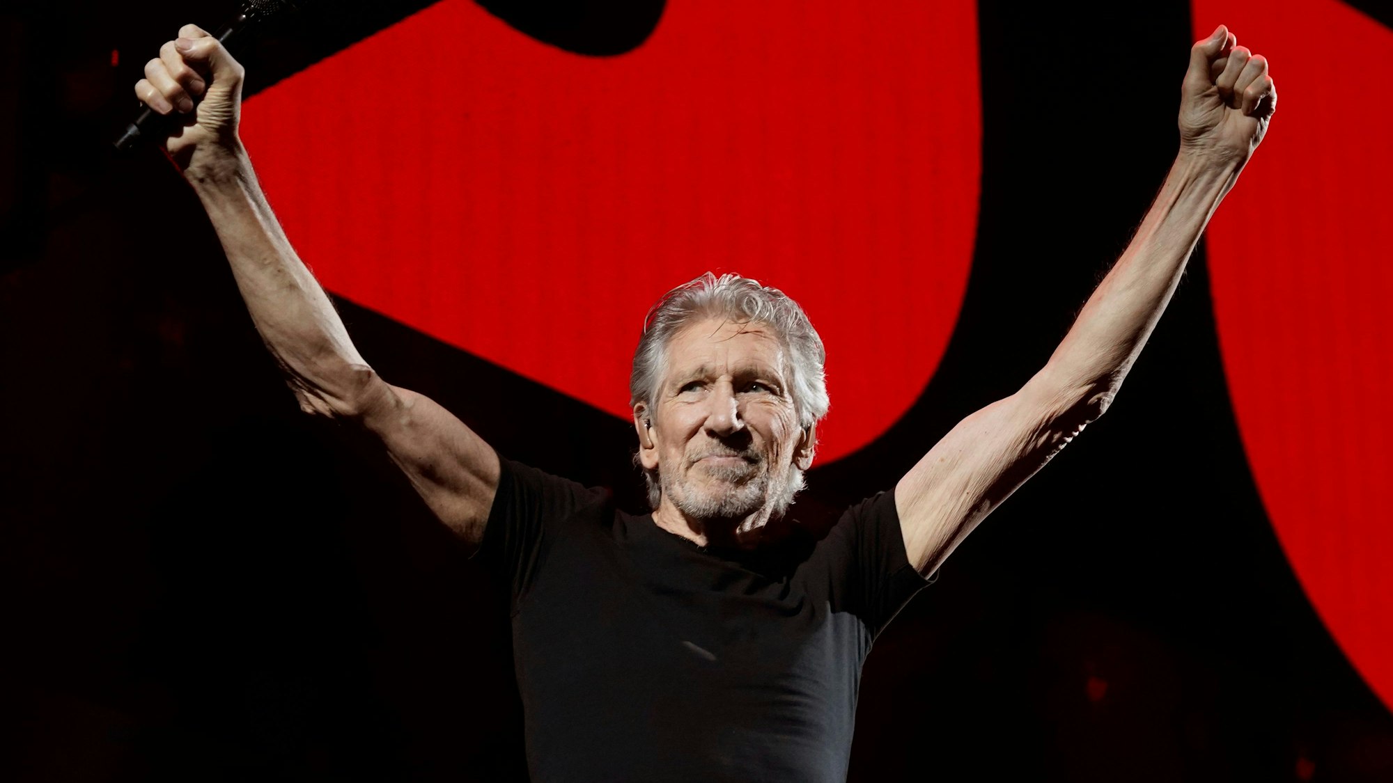 Roger Waters, Sänger, Komponist und Mitbegründer der Rockgruppe Pink Floyd, reckt auf einem Konzert in der Crypto.com Arena in Los Angeles die Arme hoch.