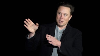 Elon Musk spricht während einer Pressekonferenz. Er gestikuliert dabei.