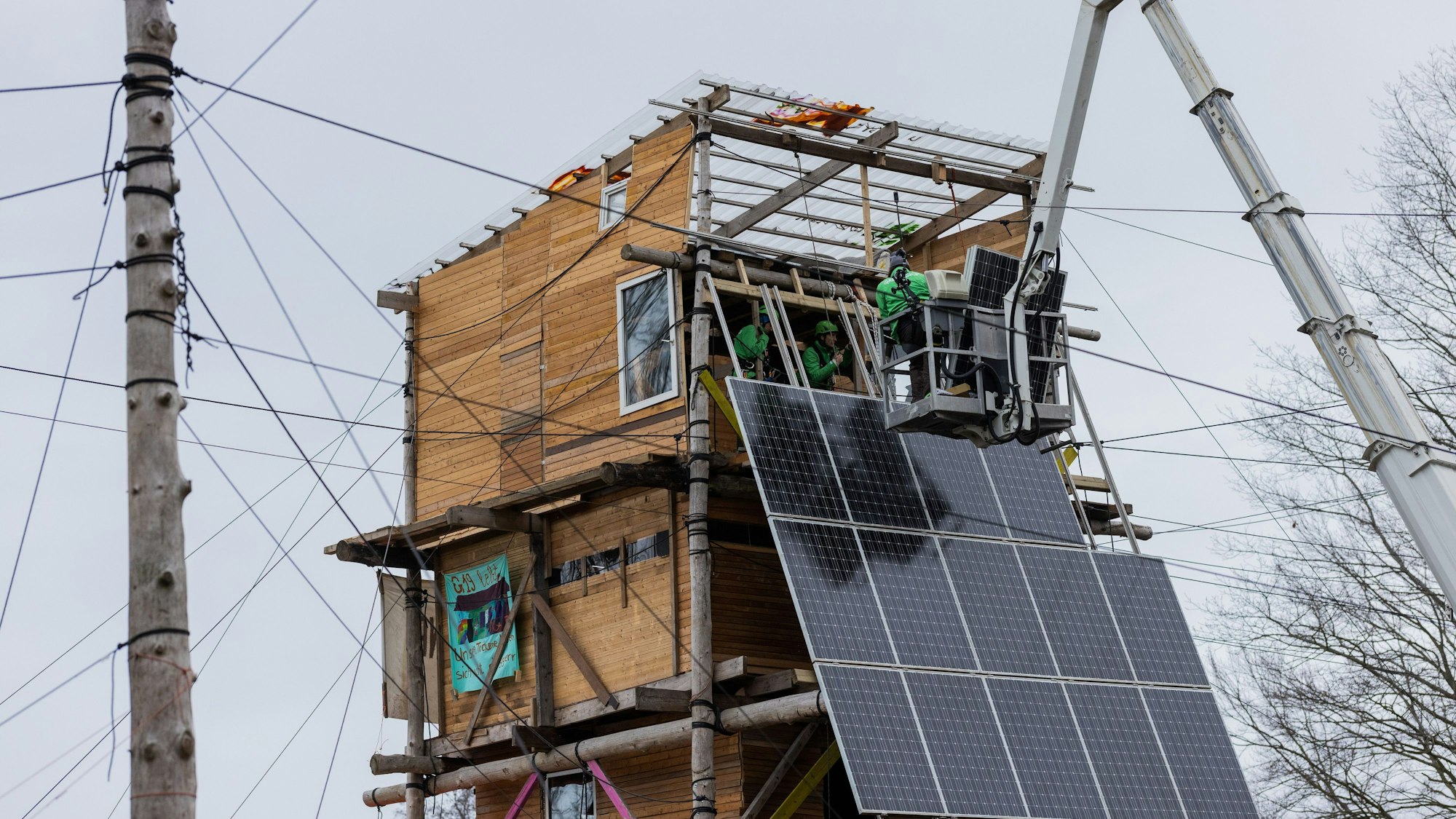 Photovoltaikanlagen werden von Greenpeace, ‚Lützerath Lebt‘ und ‚Alle Dörfer Bleiben‘ auf einem Holzturm im Protestcamp in Lützerath installiert.