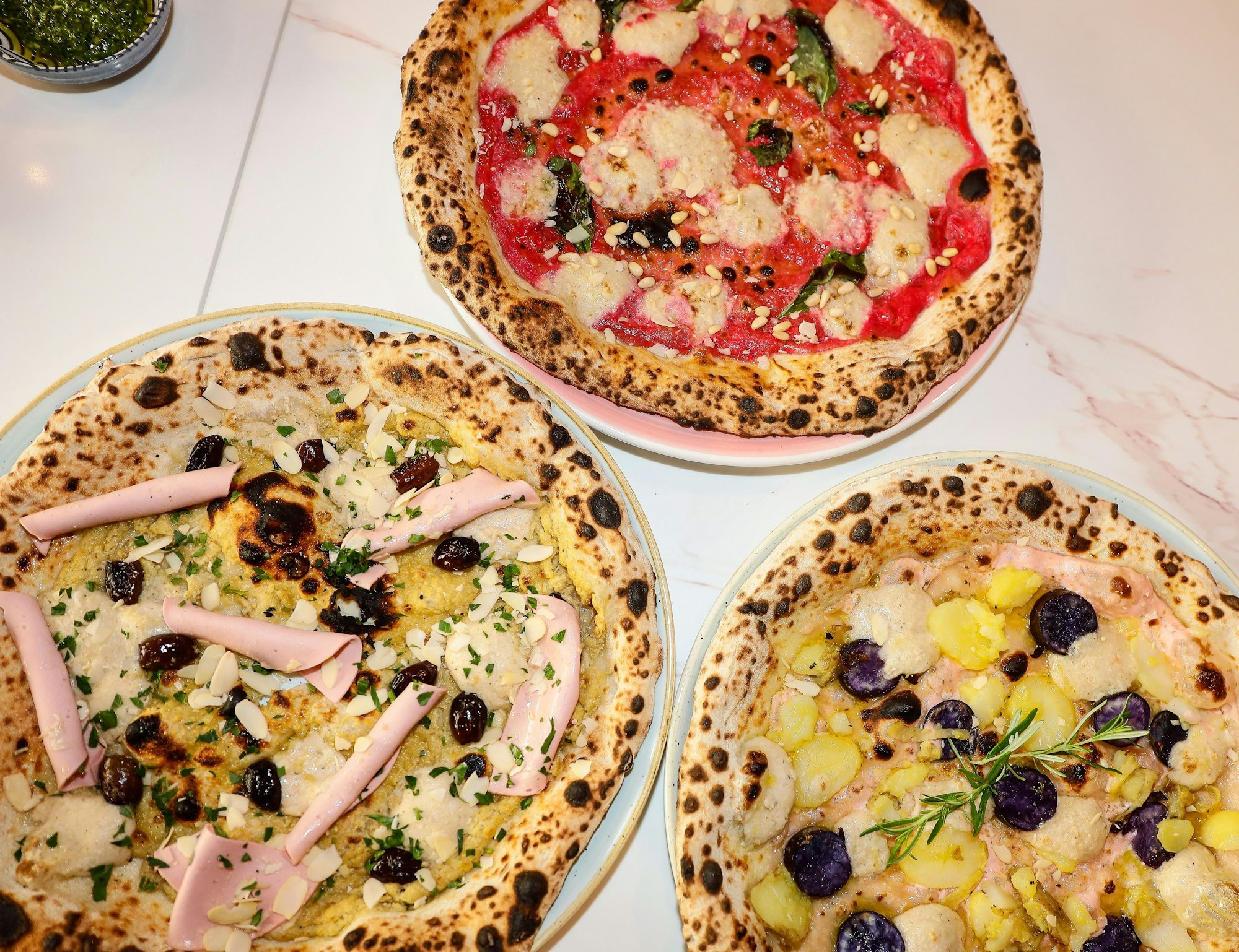 Drei verschiedene Pizzen mit unterschiedlichem Belag.