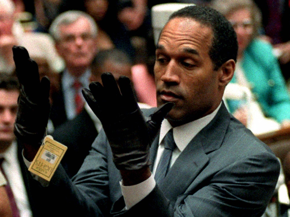 O.J. Simpson betrachtet in seinem Prozess 1995 ein neues Paar Aris-Handschuhe, die er während seines Doppelmordprozesses auf Geheiß der Staatsanwaltschaft vor den Geschworenen anziehen musste