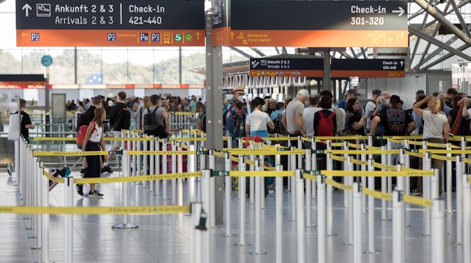 Reisende stehen in einer Warteschlange vor dem Check-In-Schalter am Flughafen Köln/Bonn.