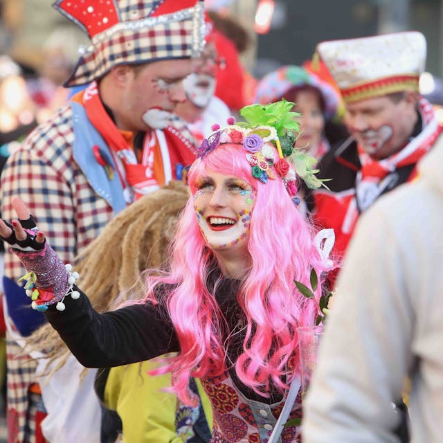 Die „Ultras GKKG“ in Karnevalskostümen, in der Mitte eine Frau mit pinker Perücke.