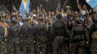 Argentinische Fans werden von der Polizei abgeschirmt. In der Lust ist Schaum.