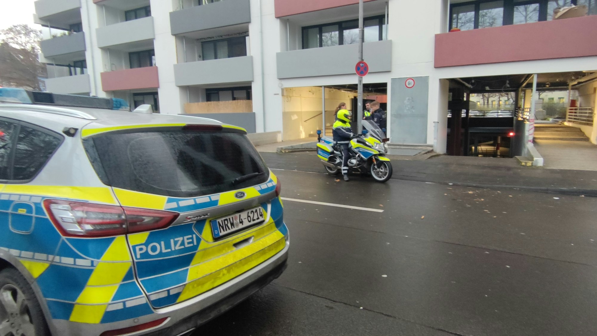 Ein Fahrzeug der Polizei steht vor einem Mehrfamilienhaus in Köln-Mülheim.