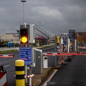 Ein Auto hält vor einer Schranke am Flughafen Köln-Bonn. Eine Ampel steht auf Gelb.