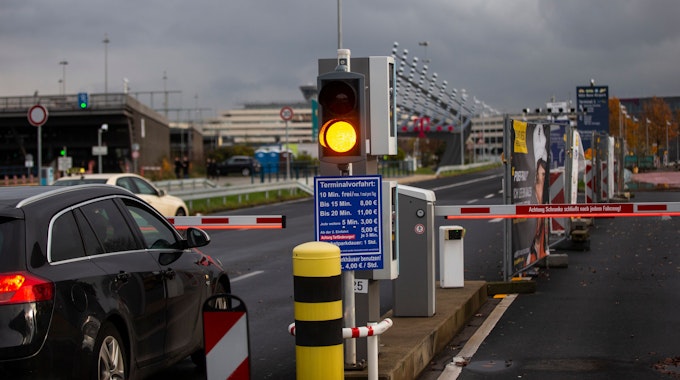 Ein Auto hält vor einer Schranke am Flughafen Köln-Bonn. Eine Ampel steht auf Gelb.