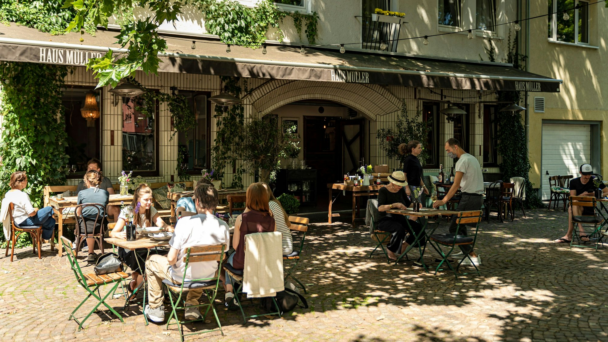 Das Restaurant Haus Müller in der Kölner Südstadt, Blick auf den Außenbereich mit Gästen
