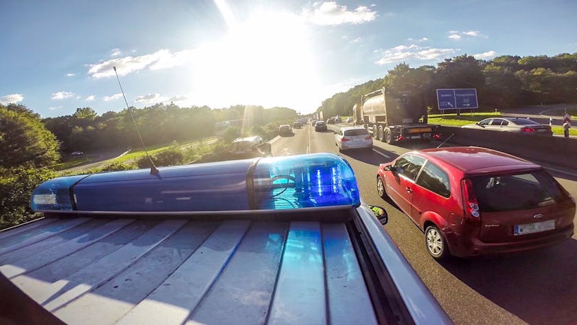 Ein Streifenwagen (VW Multivan) der Autobahnpolizei Köln fährt auf der Autobahn durch eine Rettungsgasse.