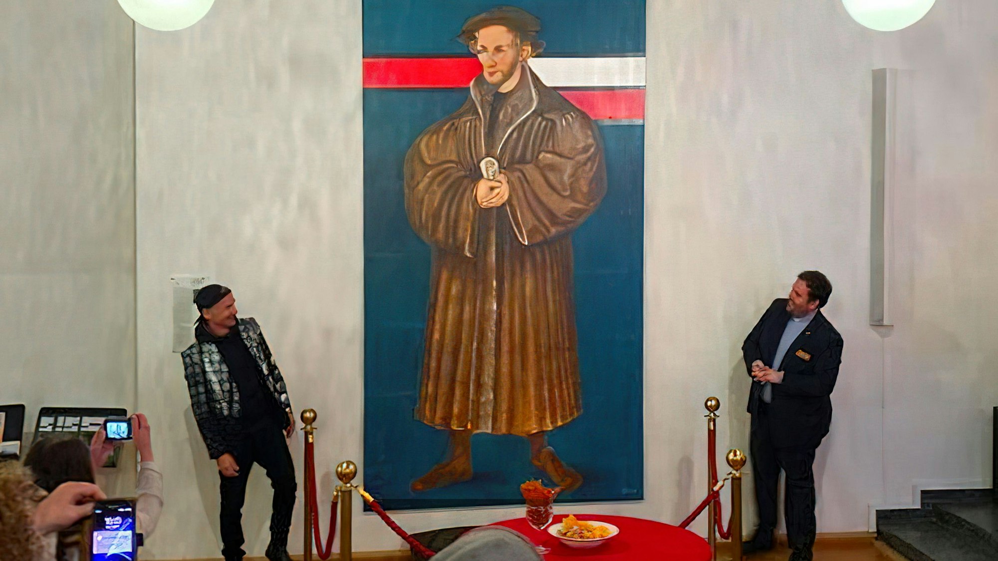 Thomas Baumgärtel und Pfarrer Mahn vor einem großen Portrait von Melanchthon.