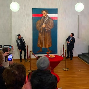 Thomas Baumgärtel und Pfarrer Mahn vor einem großen Portrait von Melanchthon.