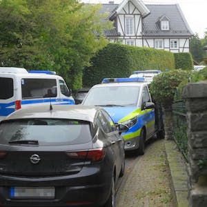 Polizeifahrzeuge sind in einer Zufahrt zu einem Gummersbacher Grundstück abgestellt. Ein Spezialeinsatzkommando durchsuchte das Anwesen im September 2020.