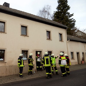 Feuerwehrleute stehen vor einem Haus in Dahlem.