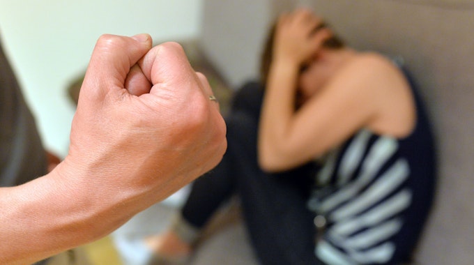 Eine Frau versucht, sich vor der Gewalt eines Mannes zu schützen (gestellte Szene).