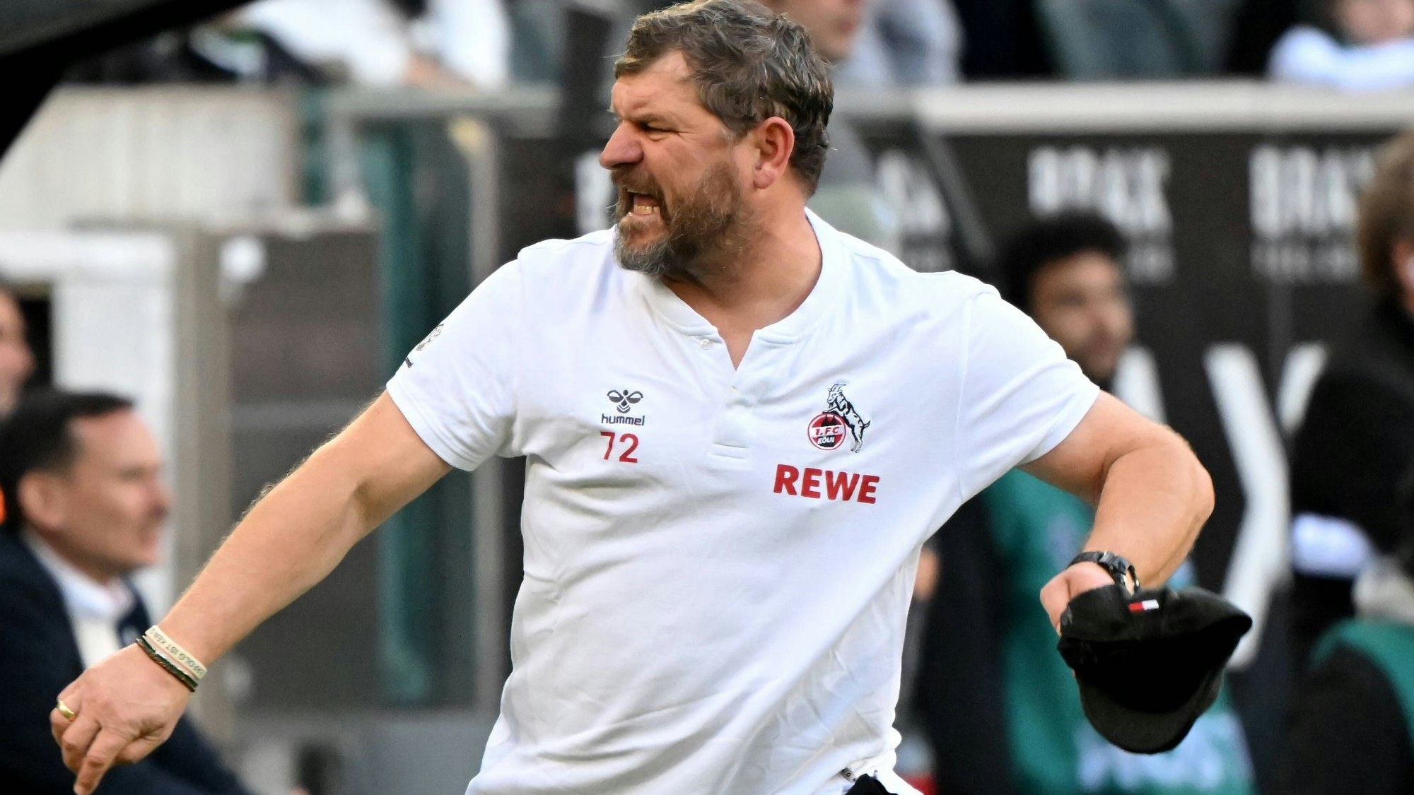 FC-Trainer Steffen Baumgart zieht sich jubelnd seine Mütze vom Kopf.
