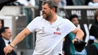 FC-Trainer Steffen Baumgart zieht sich jubelnd seine Mütze vom Kopf.