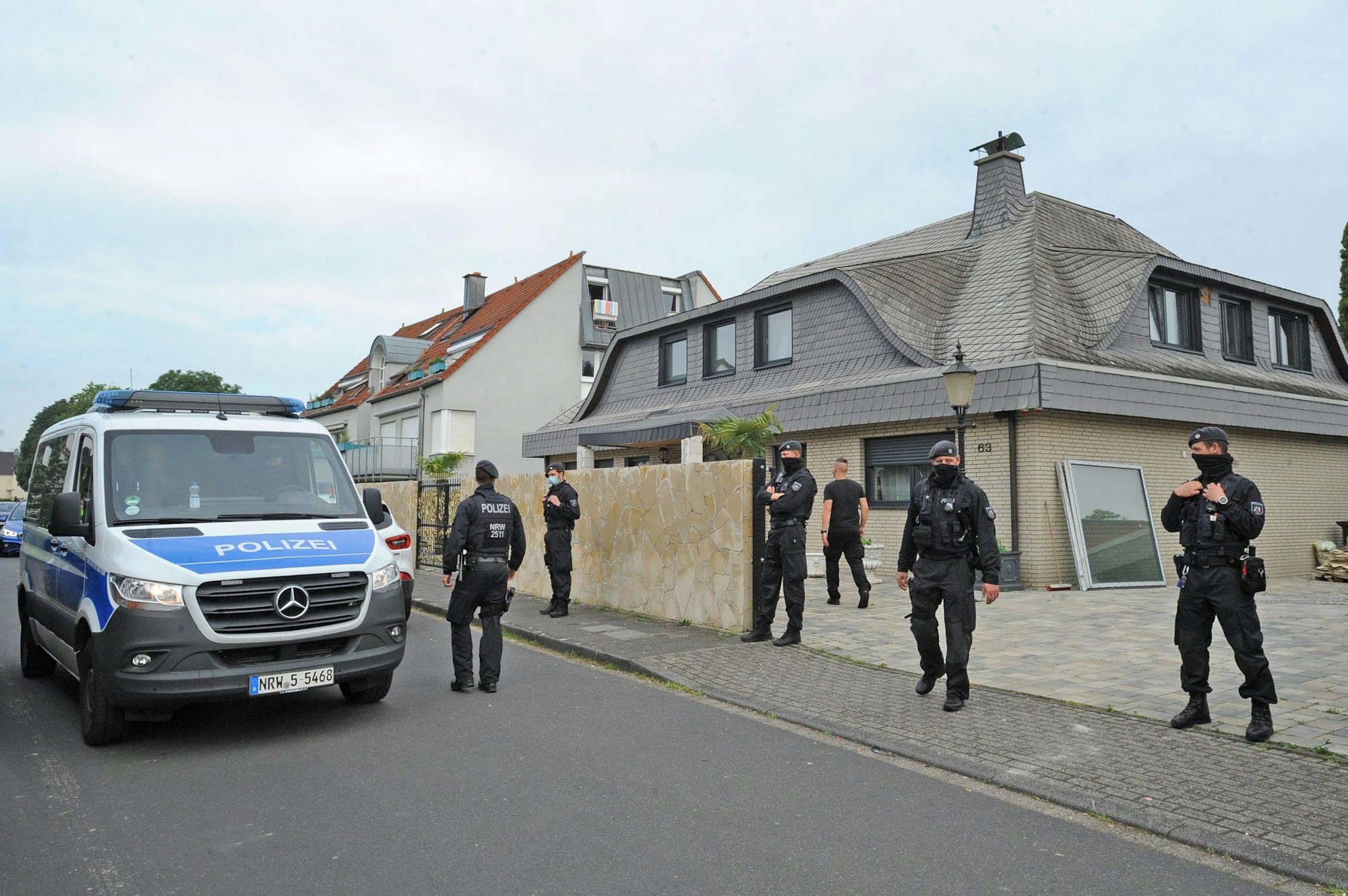 Polizisten stehen vor dem Wohnhaus der Familie Al Zein an der Straße Auf der Grieße in Leverkusen-Rheindorf .