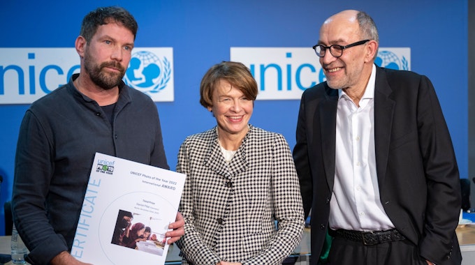 Daniel Pilar (l), bekommt den dritten Platz beim Unicef-Foto des Jahres 2022, und steht bei der Preisverleihung neben Elke Büdenbender (M), Unicef-Schirmherrin und  Ehefrau von Bundespräsident Steinmeier und Peter-Matthias Gaede, Chefredakteur des Magazins GEO und ehrenamtliches Mitglied im UNICEF-Vorstand.