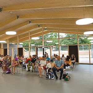In einem großen Raum in der neu gebauten Grundschule in Neschen sitzen viele Menschen.