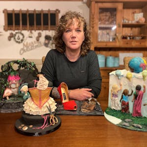 Doreen Zilske sitzt an einem Tisch, auf dem einige ihrer Kunstwerke stehen.