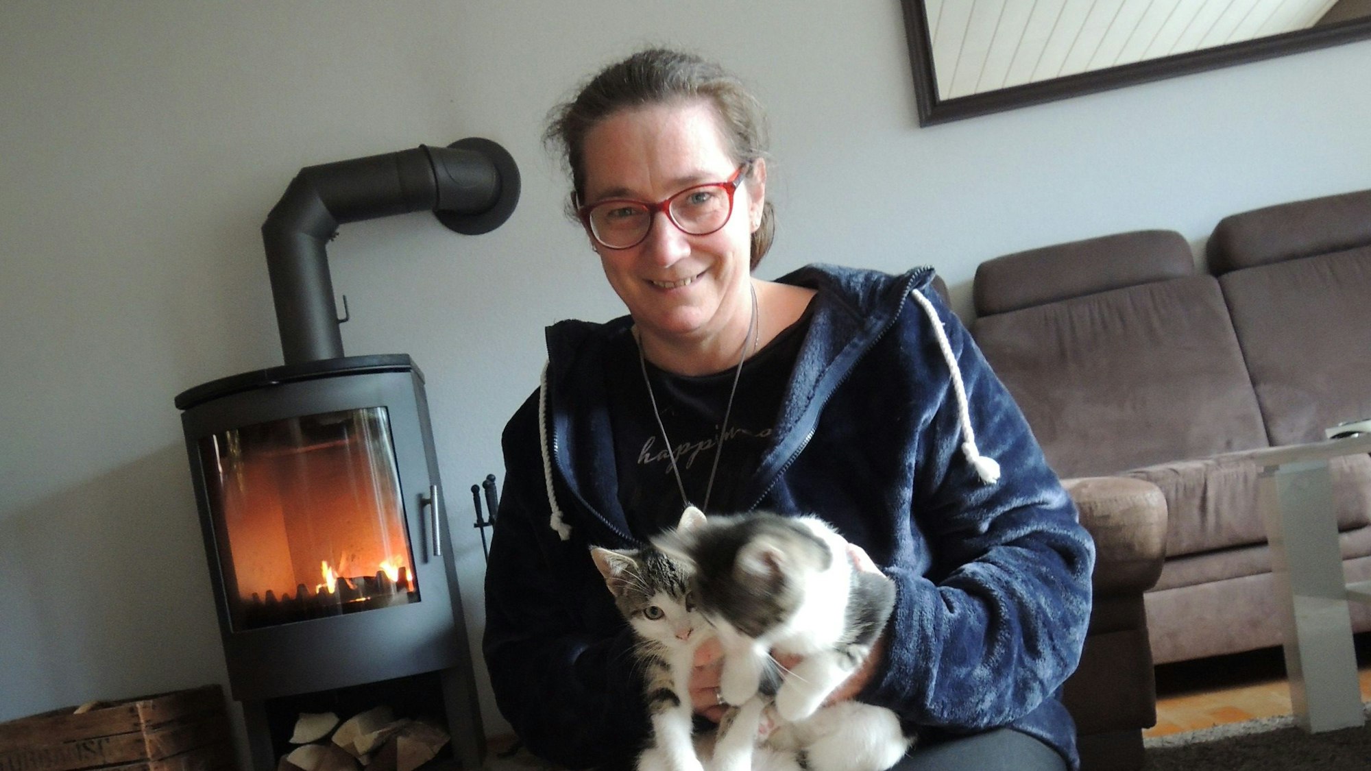 Barbara Keymer mit ihrer Katze vor dem Kamin.