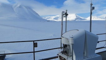 Ein technisches Gerät auf der Dach der Forschungsstation in der Arktis. Im Hintergrund ist die weiße Weite der Arktis mit hohen Bergen zu sehen.
