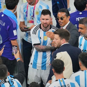Ein Mann macht mit seinem Handy ein Foto von Nusret Gokce (Mitte rechts), auch bekannt als Koch oder Salt Bae, mit dem argentinischen Nationalspieler Lionel Messi am Ende des WM-Endspiels