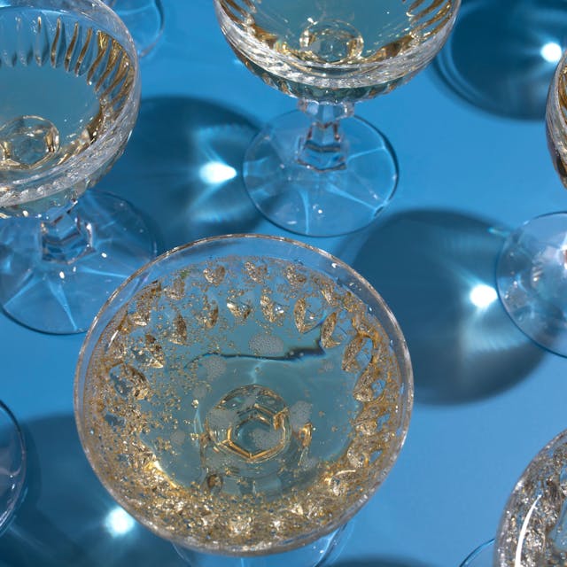 Blick von oben auf Champagnergläser auf einem blauen Hintergrund.