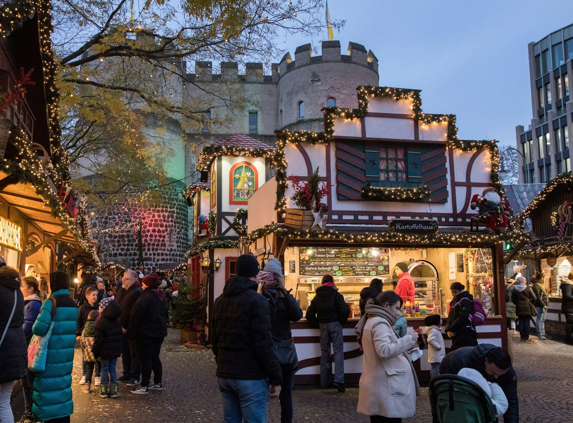 Der Weihnachtsmarkt auf dem Rudolfplatz. Im Hintergrund ist die Hahnentorburg.