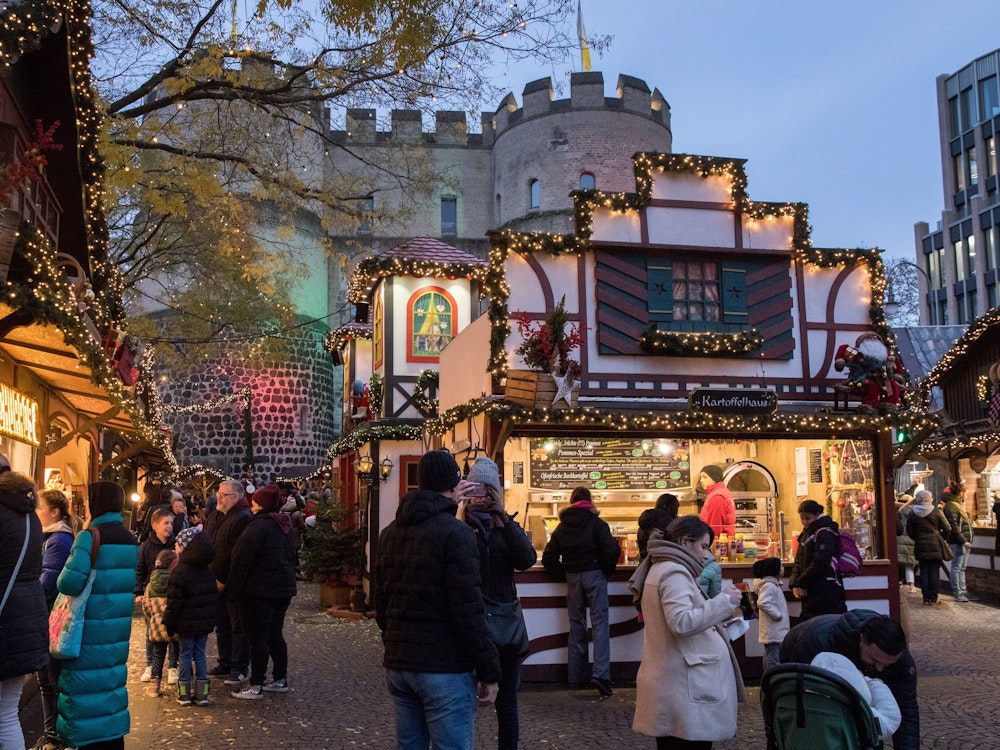 Der Weihnachtsmarkt auf dem Rudolfplatz. Im Hintergrund ist die Hahnentorburg.