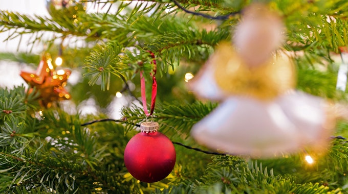 Weihnachtsschmuck hängt an einem Christbaum.