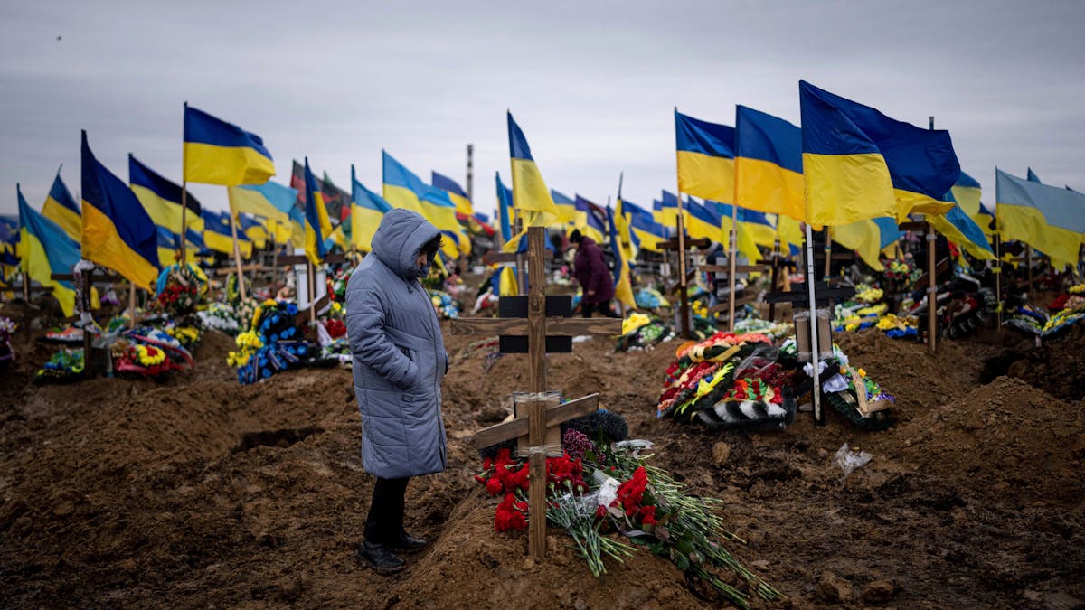 Eine Frau betrachtet das Grab ihres Mannes, einem ukrainischen Soldaten, der an der Frontlinie gestorben ist.