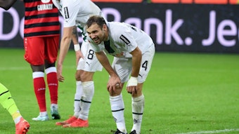 Tony Jantschke geht im Spiel von Borussia Mönchengladbach gegen den VfB Stuttgart mit schmerzverzerrtem Blick in die Knie und stützt sich im eigenen Strafraum ab.