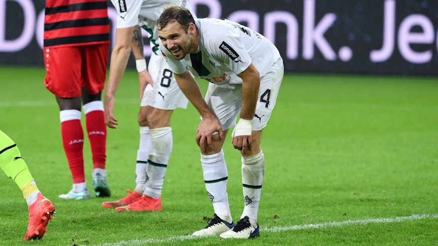 Tony Jantschke geht im Spiel von Borussia Mönchengladbach gegen den VfB Stuttgart mit schmerzverzerrtem Blick in die Knie und stützt sich im eigenen Strafraum ab.