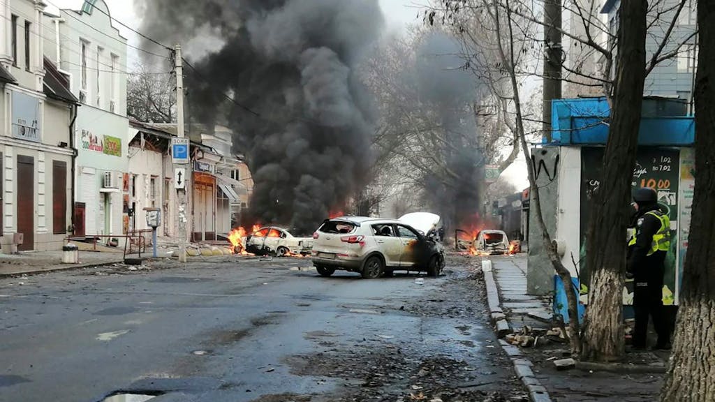 In Cherson (Ukraine) brennen am 24. Dezember 2022 Autos und Rauch steigt auf, nachdem ein russischer Raketenangriff das Stadtzentrum getroffen hat.