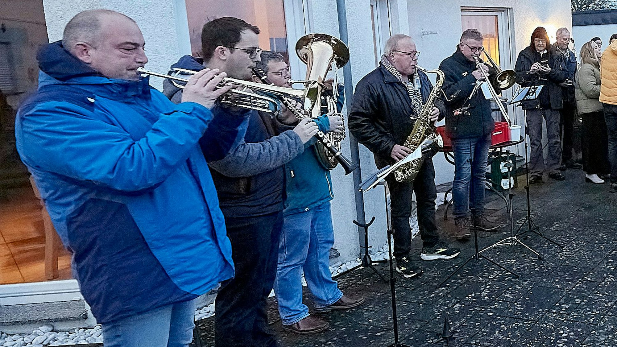 Fünf Musiker der „Kapelle unterwegs“ spielen auf der Terrasse von Wolfgang Booch Weihnachtslieder.