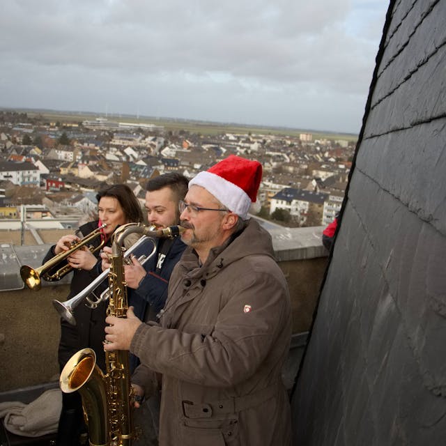 Lea Klose, Bastian Guthausen und Markus Tews spielen auf dem Turm der Herz-Jesu-Kirche Euskirchen Weihnachtslieder.