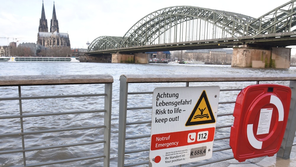 Hochwasser am Rhein, ein Schild weist auf Lebensgefahr hin.